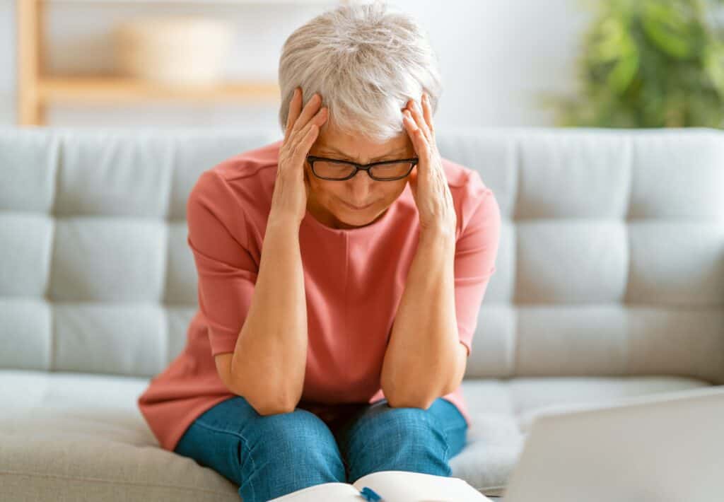Senior exhausted woman having headache
